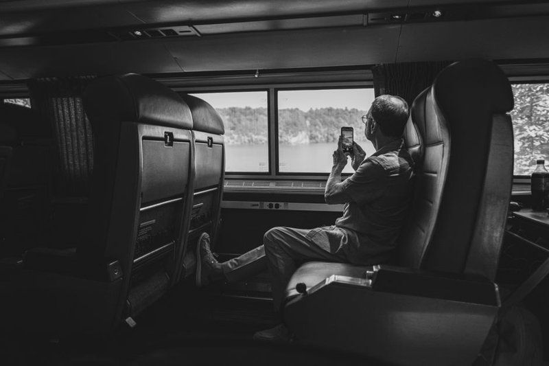 乘客在火车上使用手机拍照